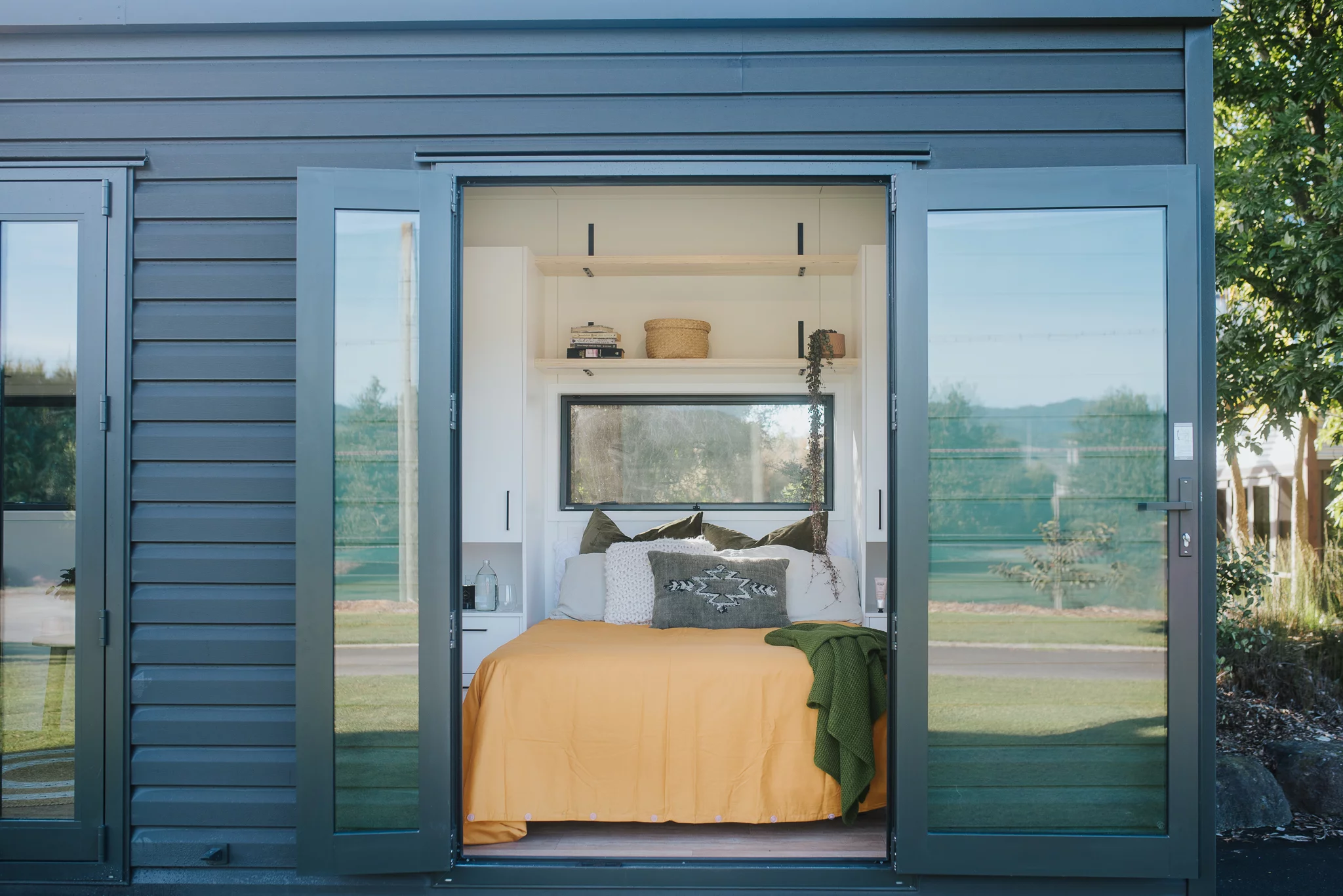 The Piwakawaka's bedroom opens up to the outside with double glass doors
