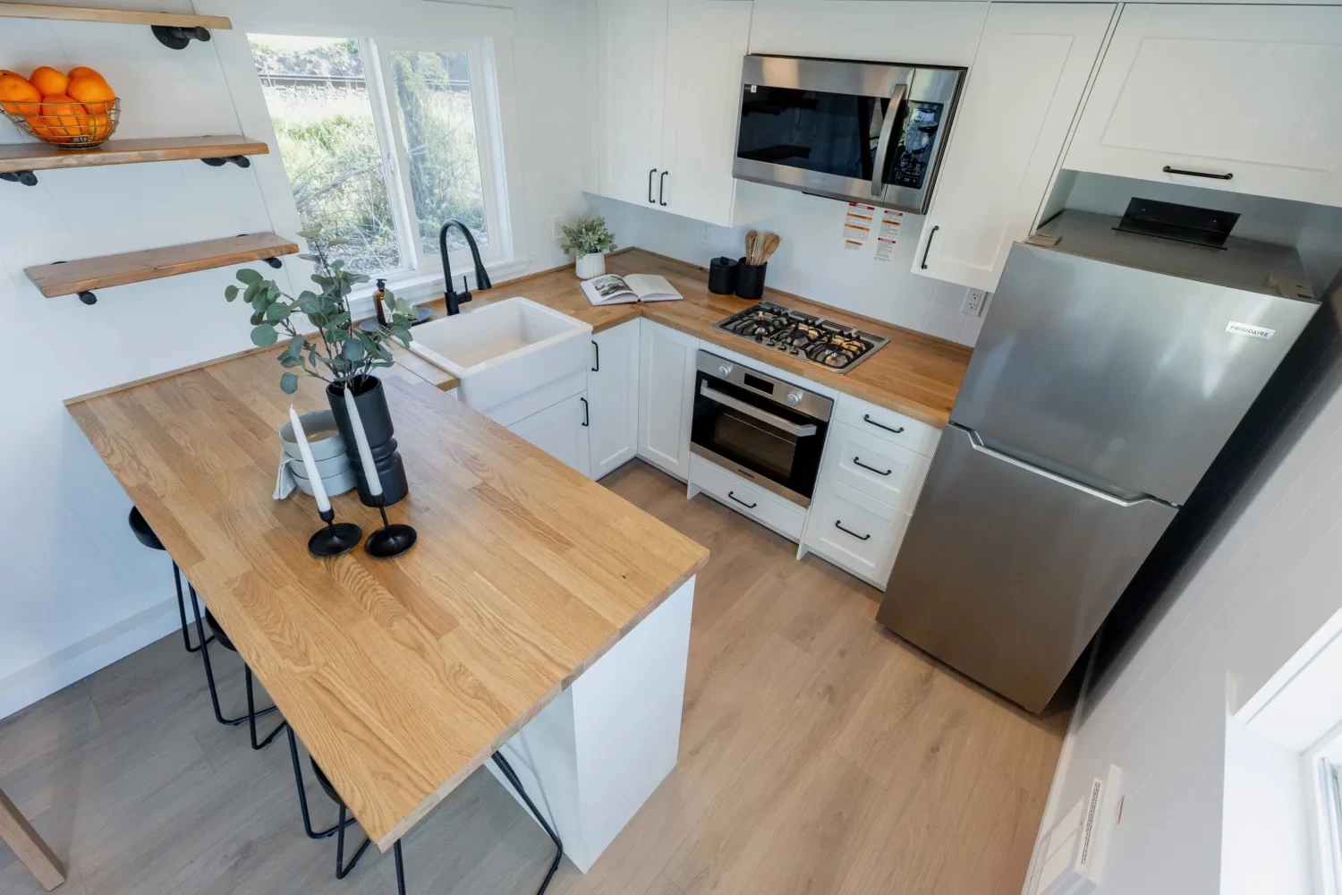 The Ventura Park Model Tiny Home's kitchen is arranged into a U shape and includes a breakfast bar with stool seating