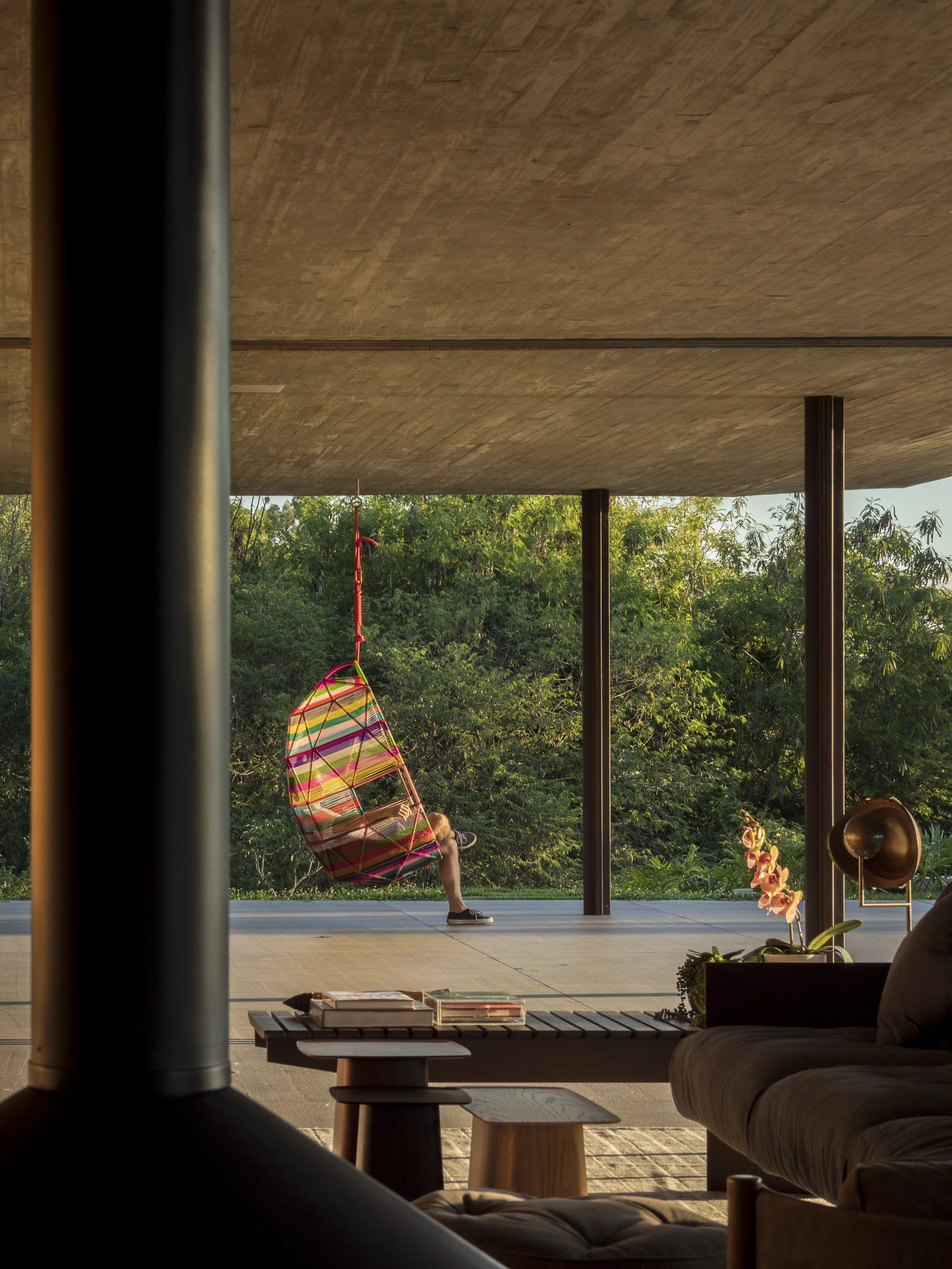 A multi-colored hanging chair is installed in Planar House's terrace area