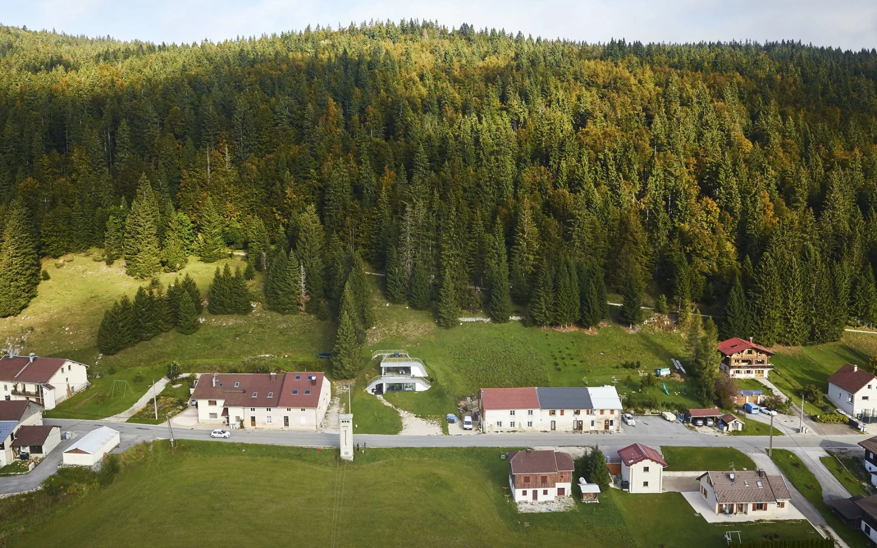 In France sits Casa Jura, a residential home built into the surrounding hill leaving just a couple of small outcrops to allow light in