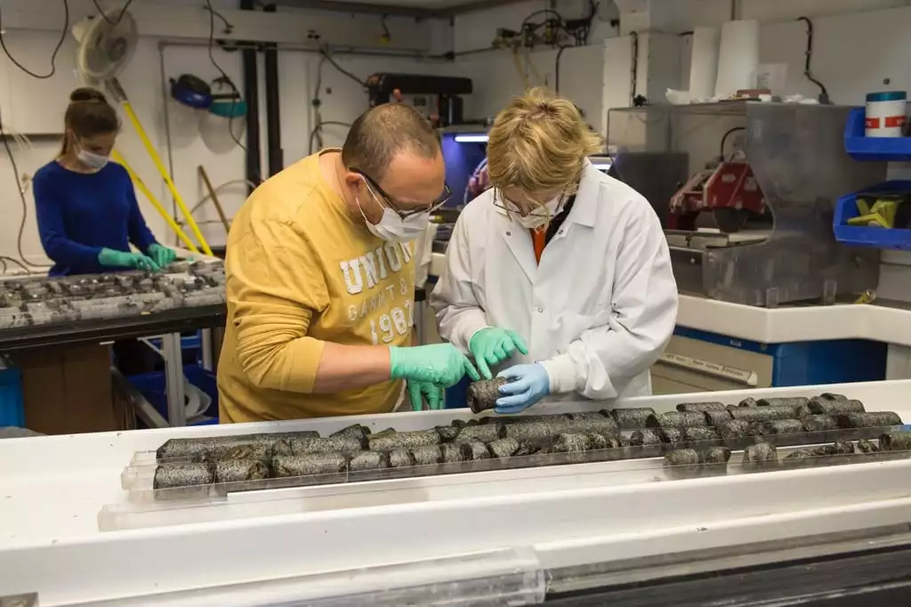 Benoit Ildefonse (left) and Virginia Edgcomb (right) examine cores taken from the seafloor of the Indian Ocean