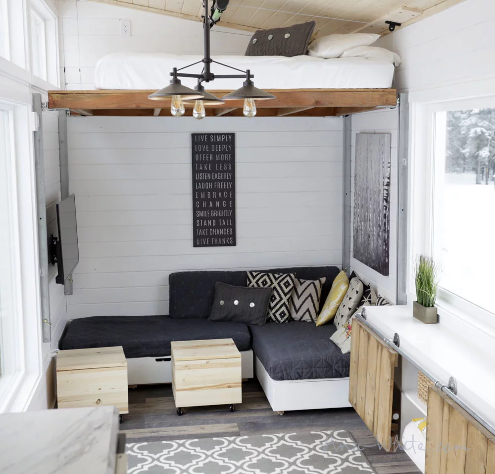 The Open Concept Rustic Modern Tiny House's elevating bed in its most raised position