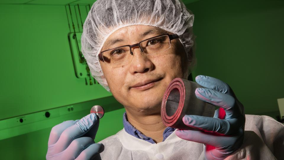 Shouyuan Chen, UNL research assistant professor of physics and astronomy, shows a uranium disk and steel casing
