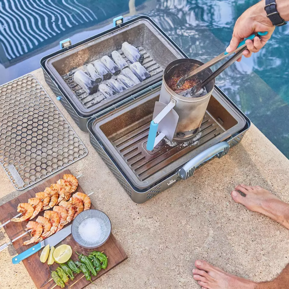 Folded open, the Nomad Grill and Smoker features two empty beds that can be filled with charcoal