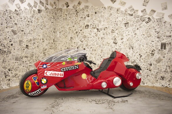 Exhibition visitors can have their picture taken sitting on the bike among a post-apocalyptic backdrop