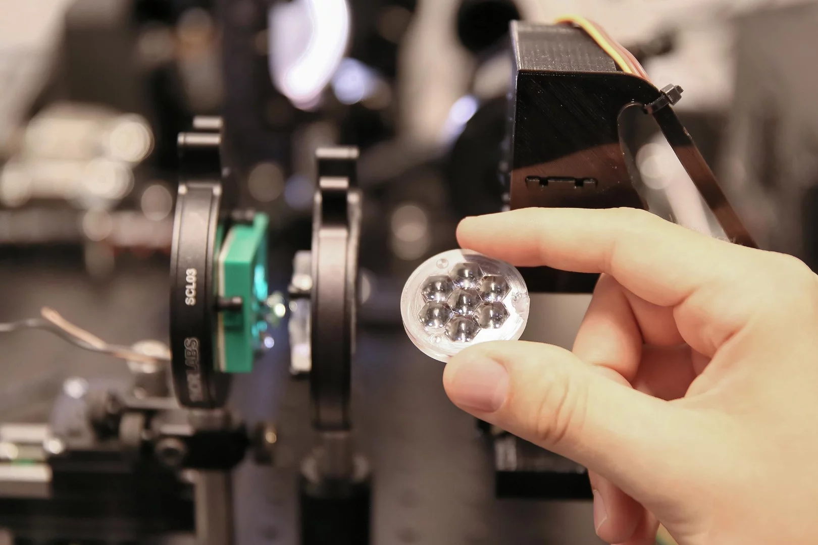 The top layer of tiny lenses directs sunlight to a small, very high performance solar cell