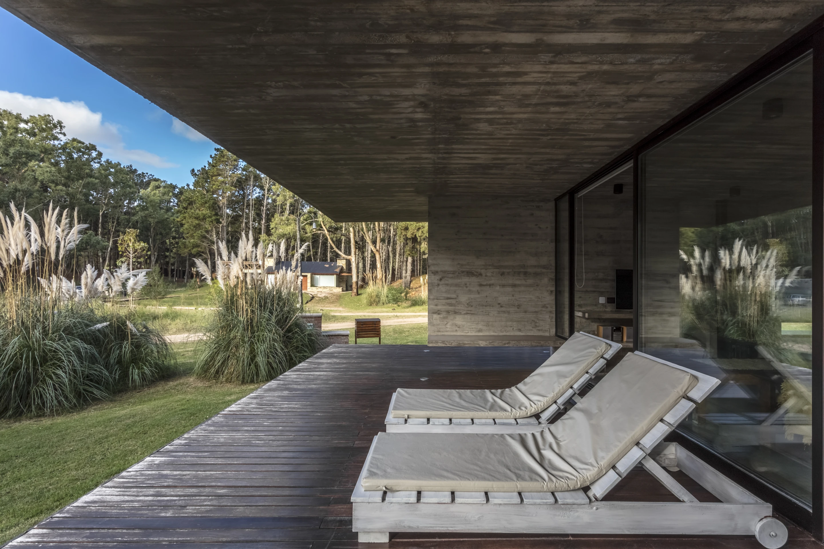 A living area opens up to a covered balcony in the Forest House, by Besonias Almeida