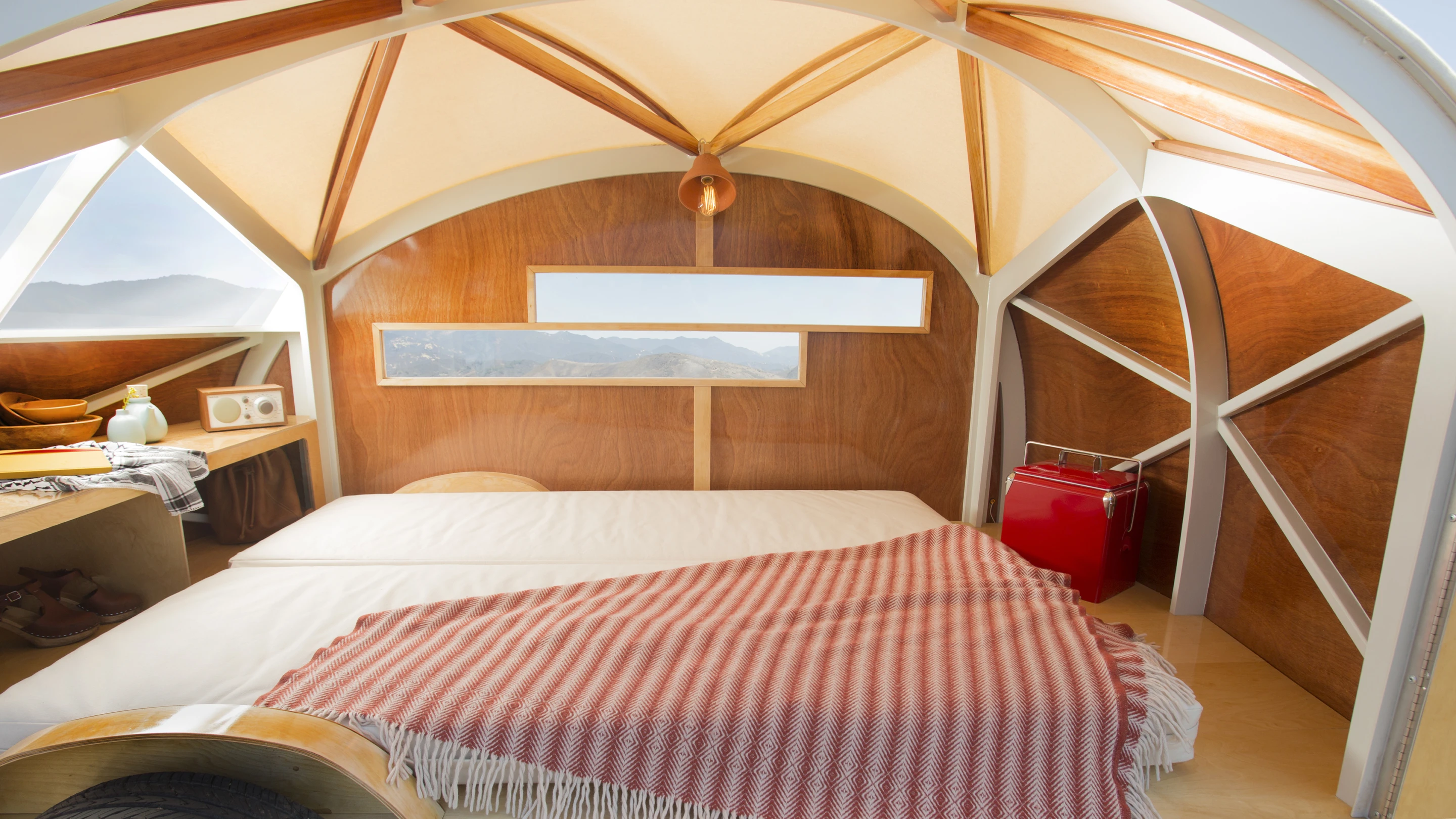 It features a bed that sleeps two adults, a good number of windows, a light, and a little storage space