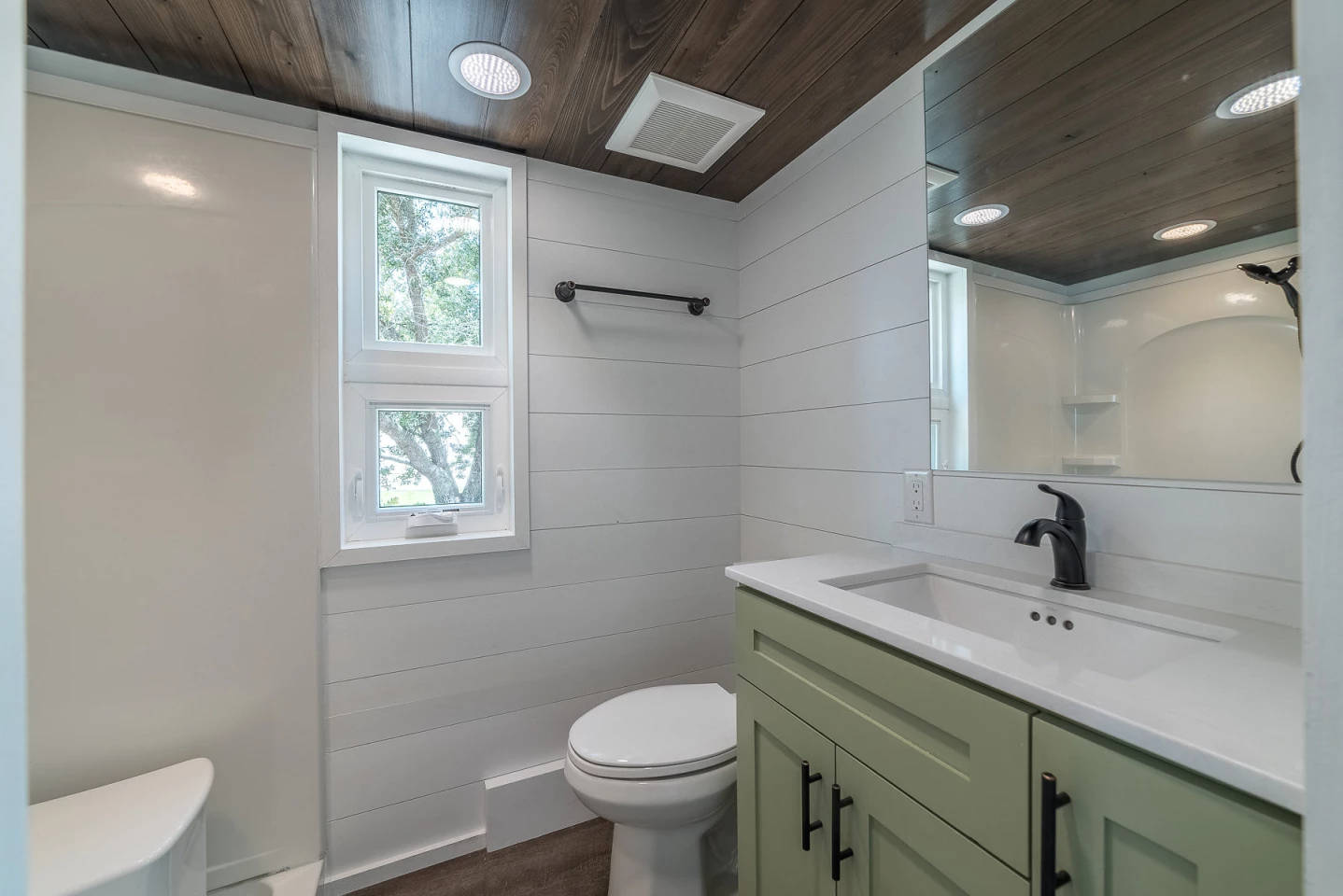 The bathroom features ample storage and clean lines. A residential toilet makes you feel right at home atop your throne