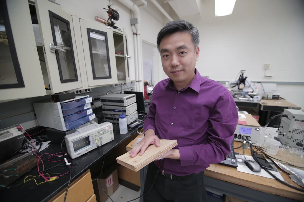 Xudong Wang, from UW-Madison, with a prototype section of the energy-harvesting flooring