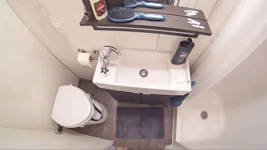 The bathroom is equipped with a sink, vanity, compositing toilet and full fiberglass shower