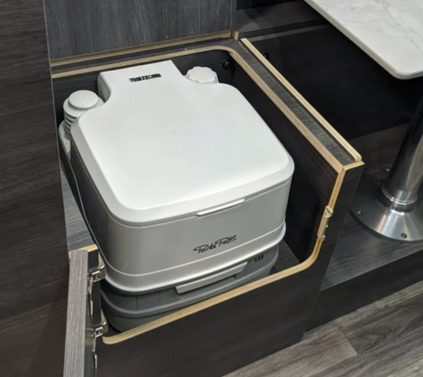 Toilet below the rear bench seat