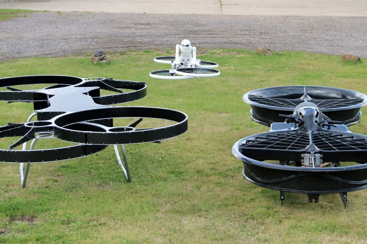 From left to right: the second prototype Hoverbike, the drone (in flight), and the original dual-rotor prototype (Photo: Chris Wood/Gizmag)