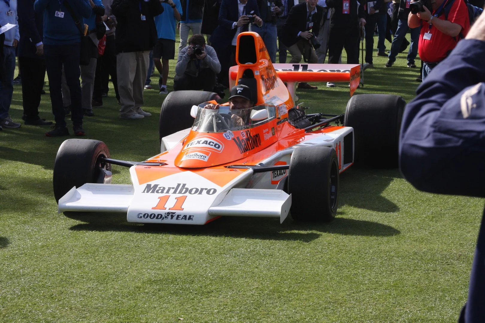 Twice winner of the World Formula One drivers Championship and two time Indianapolis 500 winner Emerson Fittipaldi was the guest of honor at Amelia Island, thrilling the crowds with an array of machinery he raced during his illustrious career. Here Emerson is pictured in the 1974 McLaren M23 in which he gave the now stellar marque its first of many drivers and constructors titles.