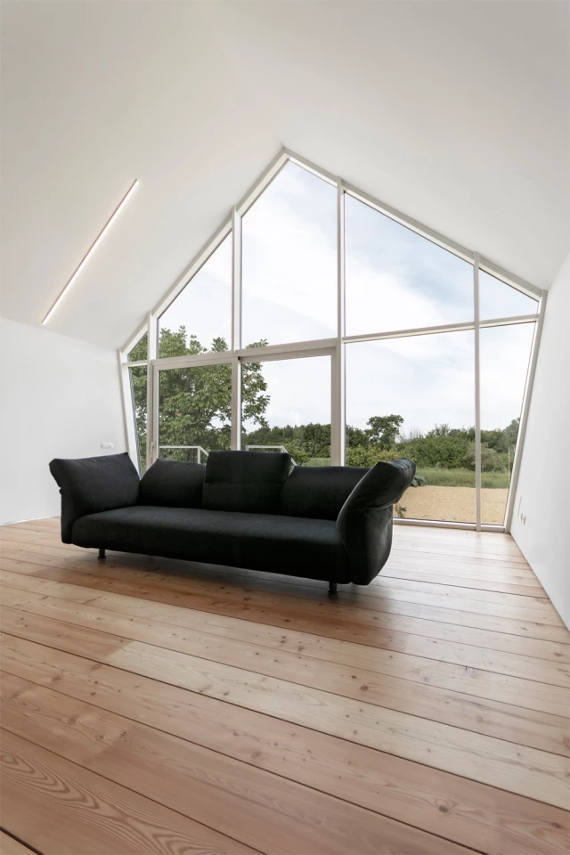 The interior design features an open lounge/living area with log fire and lovely views across the surrounding gardens