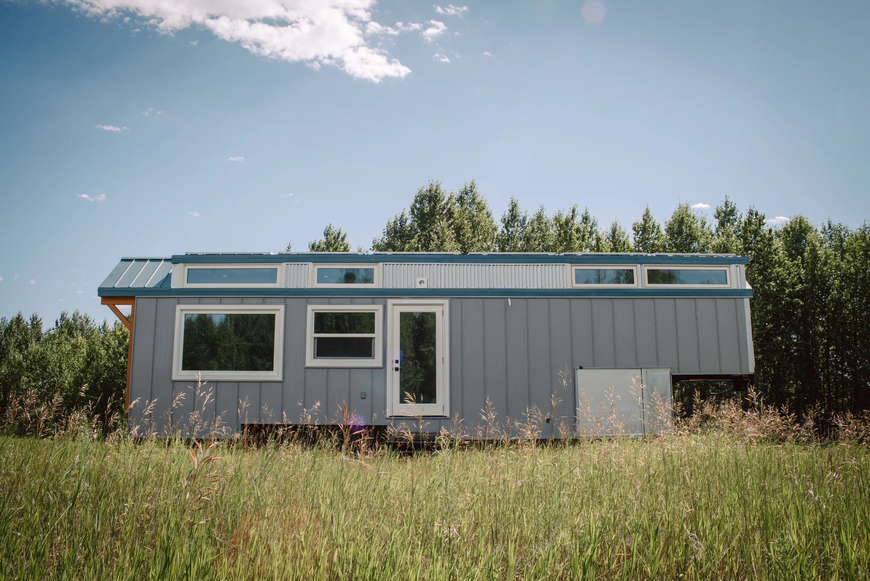 The Macdonald tiny house features a secondary entrance at the side of the home that opens into its kitchen