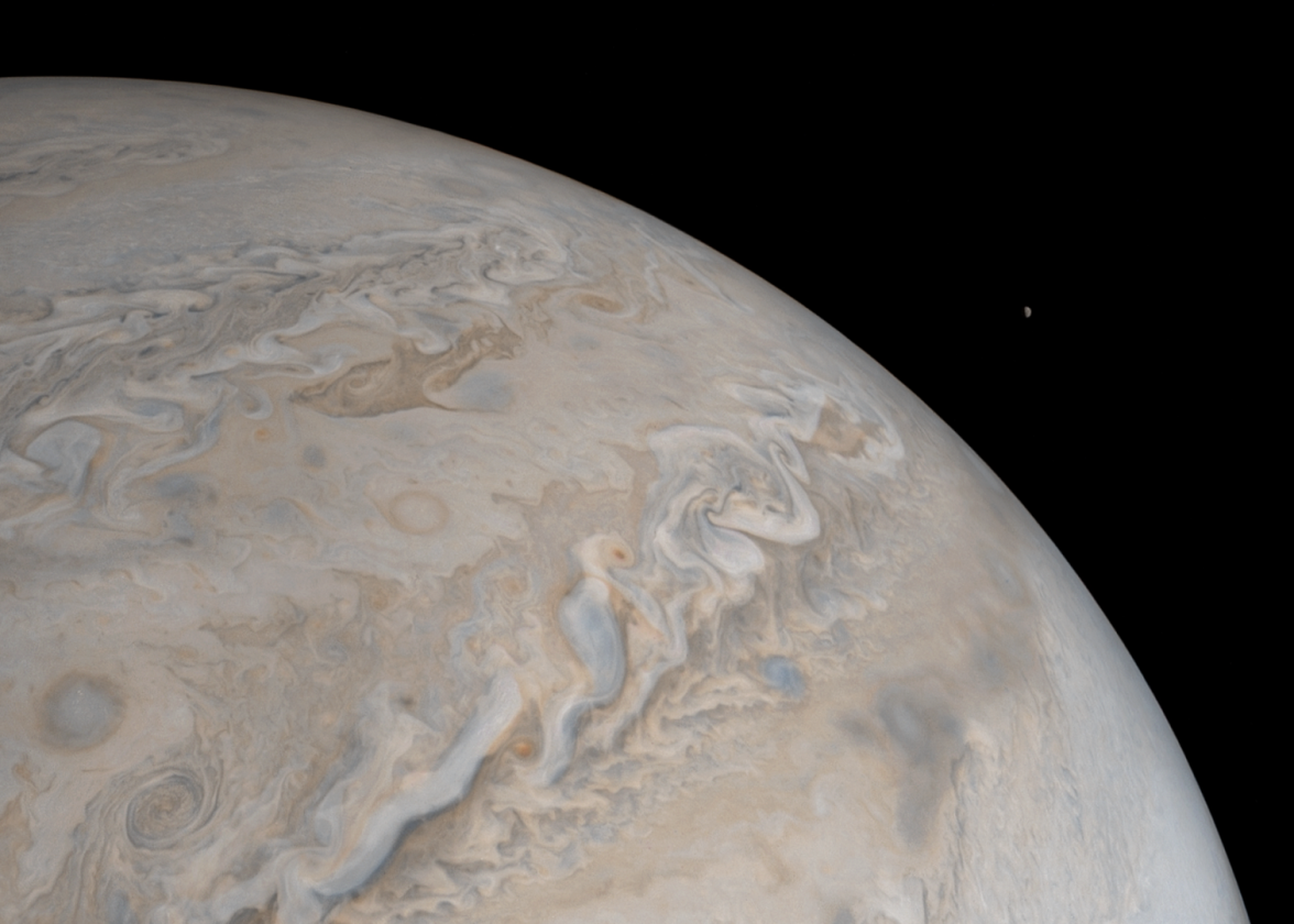 A remarkable shot featuring both the dolphin cloud and Jupiter's moon Io rising in the background