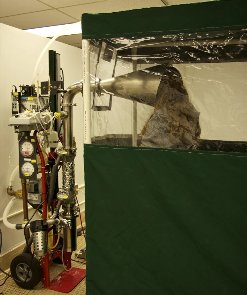 A study participant sits in the Gesundheit II machine, which is used to capture and analyze influenza virus in exhaled breath