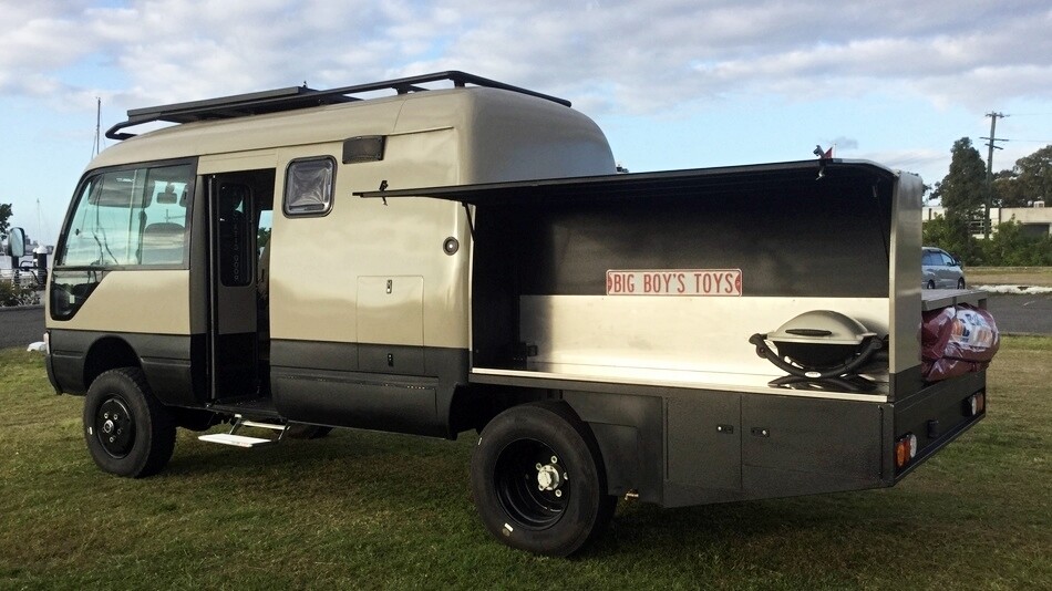 An even weirder build from Bus 4x4, this Toyota Coaster-based motorhome is sort of half folding trailer, half camper van