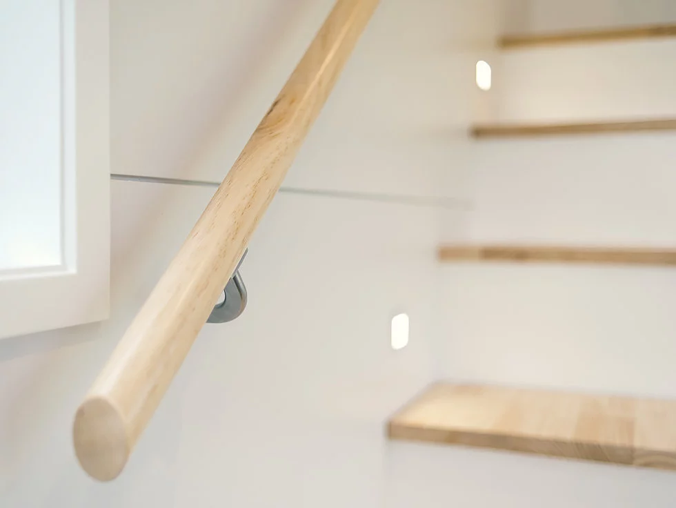 The Buster Tiny House's bedroom is reached by storage-integrated staircase