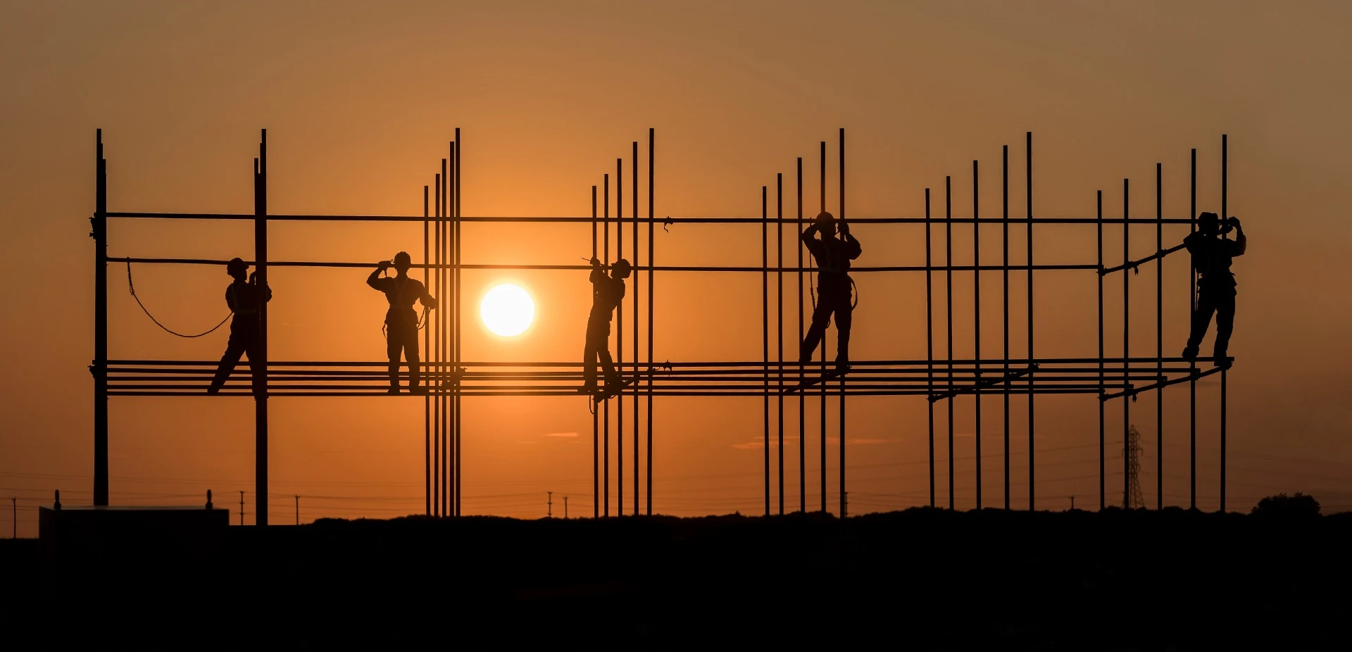 Construction workers toil away as the sun sets over Manitoba, Canada