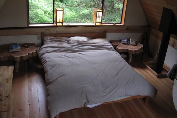 The upstairs quarters features a low queen size bed made from natural latex foam, a dresser, a bookshelf, two simple tables and Japanese style lanterns