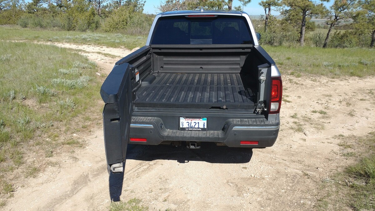 Grasping the secondary latch handle (to the right, near the tail lamp) swings the tailgate of the 2017 Honda Ridgeline to the left for easier loading of bulky items