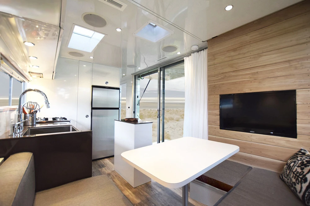 This living area in the Living Vehicle features a 32-inch LED wall-mounted TV and four-speaker sound system with Bluetooth connectivity