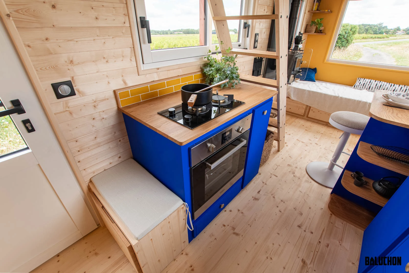 The kitchen in Leïla's tiny house features an oven and two-burner propane-powered stove, plus a small fridge/freezer