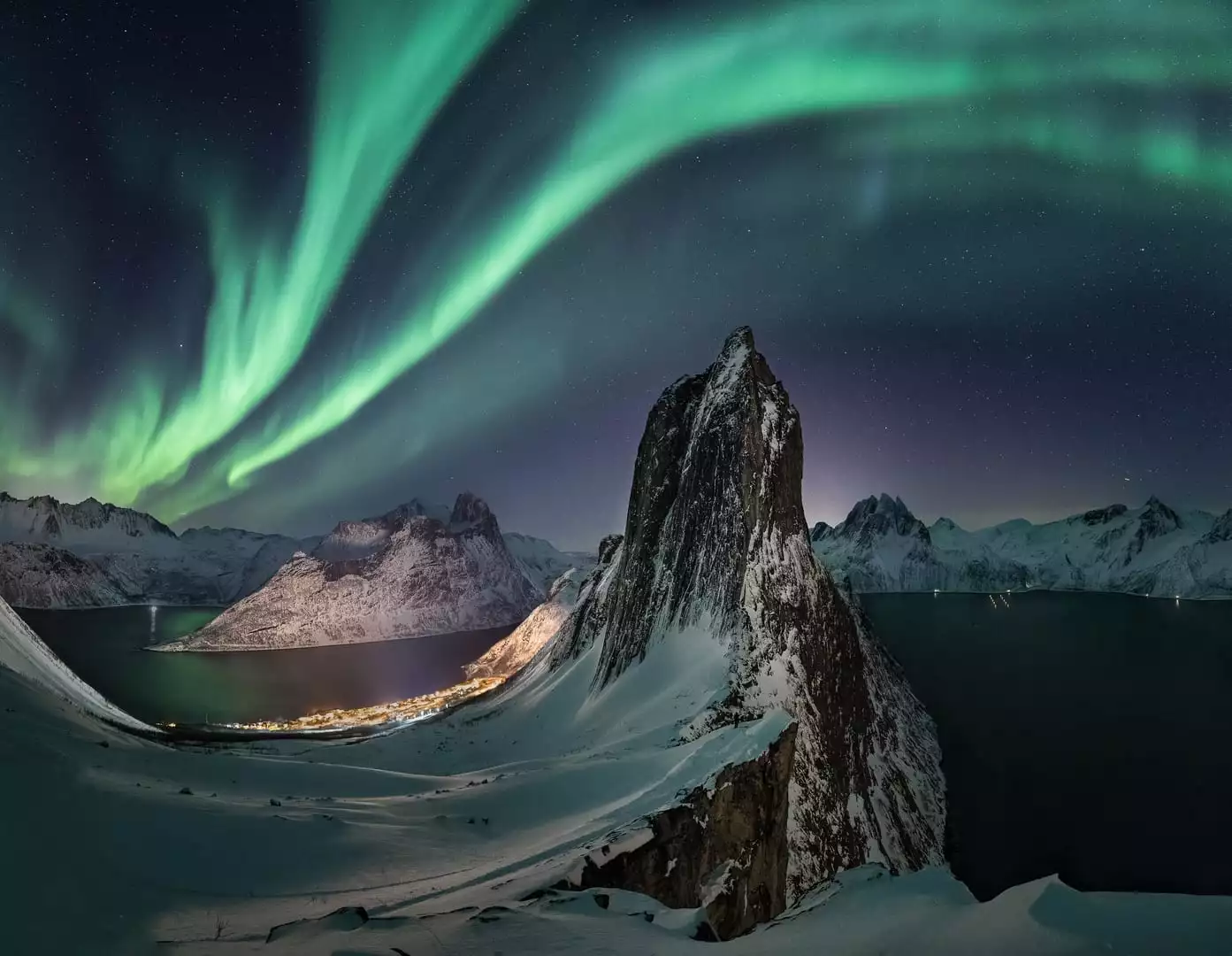 The Northern Lights Cathedral by Frøydis Dalheim, snapped in Senja, Norway. The aurora snakes its way across the sky, above a spectacular rock formation that conjures images of the divine.