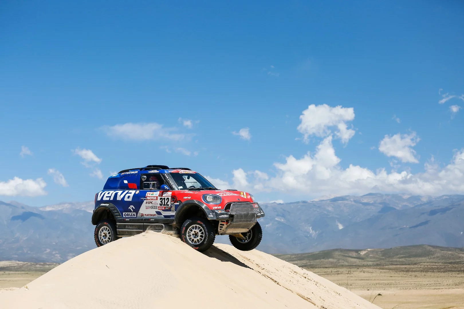 Mini drivers Jakub Przygonski and Tom Colsoul, beached as against a beautiful Andes mountains backdrop