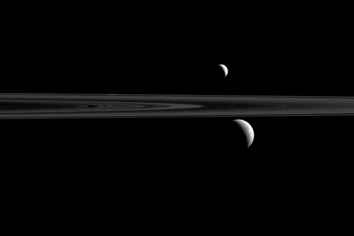 Saturn's rings divide Enceladus (top) and Rhea (below)