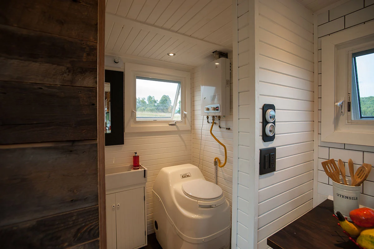 The Greenmoxie Tiny House has a bathroom with shower, composting toilet, and sink