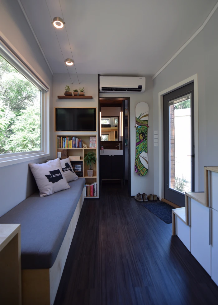 The livable layout includes one sleeping loft, a main living space, bathroom, kitchenette, and gear room