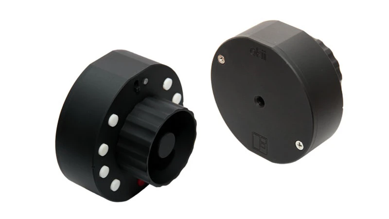 The Okii Systems USB Follow Focus features a rugged aluminum housing with a central focus knob and a threaded mount on the back