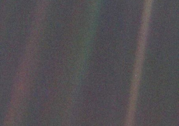 Voyager 1's iconic pale blue dot, with Earth featured as a tiny spec in the light band on the right of the image