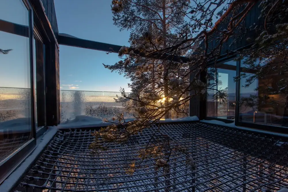 Raised 10 m (32 ft) above a forest floor in Swedish Lapland, the luxury 7th Room treehouse lets visitors sleep out under the stars on a netted terrace