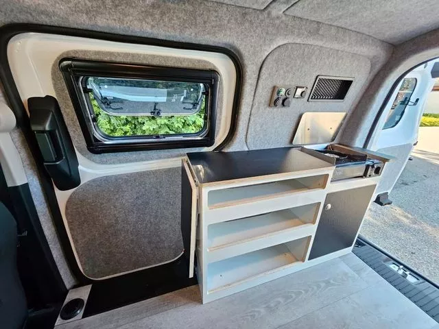No sink, but Alpincamper's tiny kitchenette does include a stove, extendable worktop and a fridge across the way