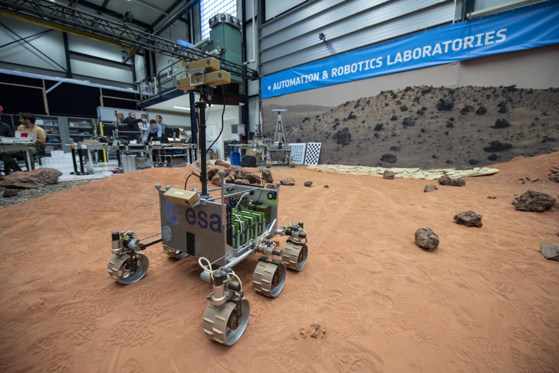 ExoMars Testing Rover (ExoTeR), seen maneuvering itself carefully through the red rocks and sand of the Planetary Utilisation Testbed