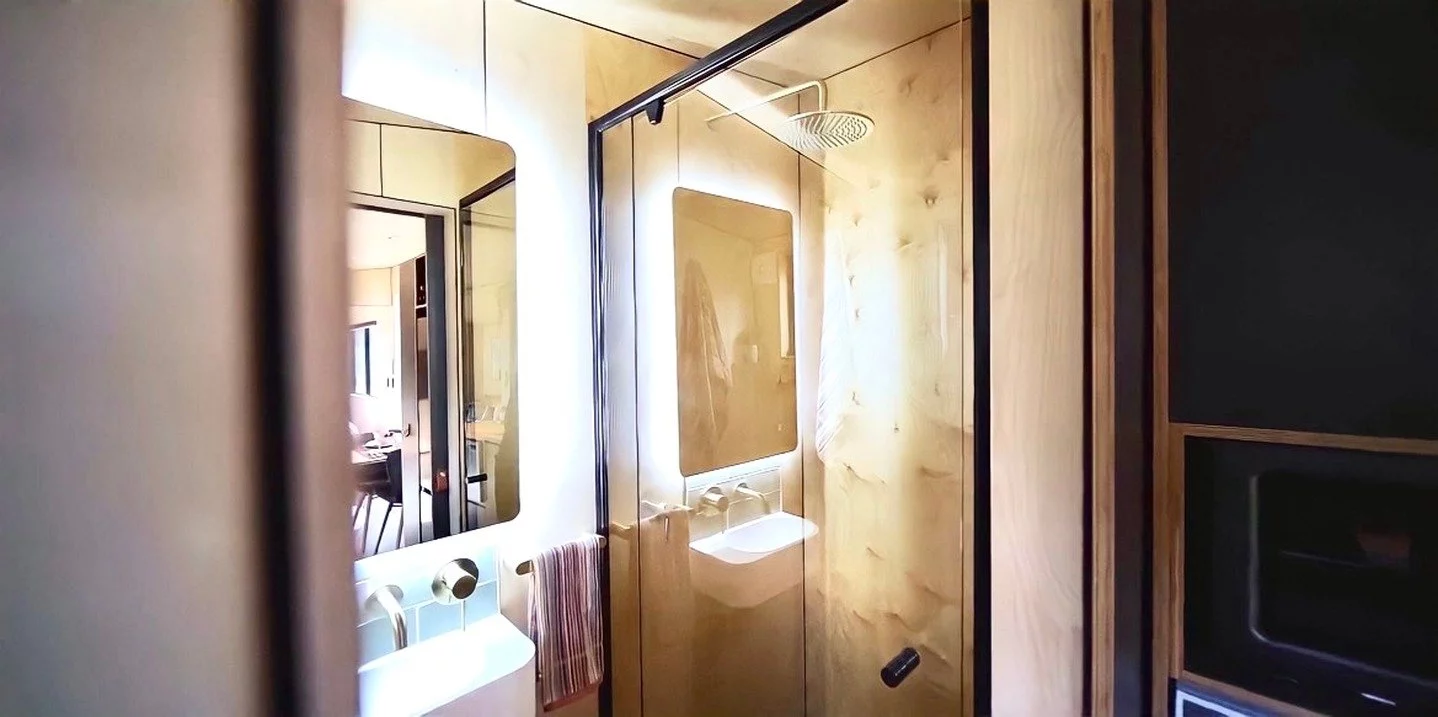 The Luna tiny house's bathroom has a shower, vanity sink, and flushing toilet as standard, which can be upgraded to a composting model