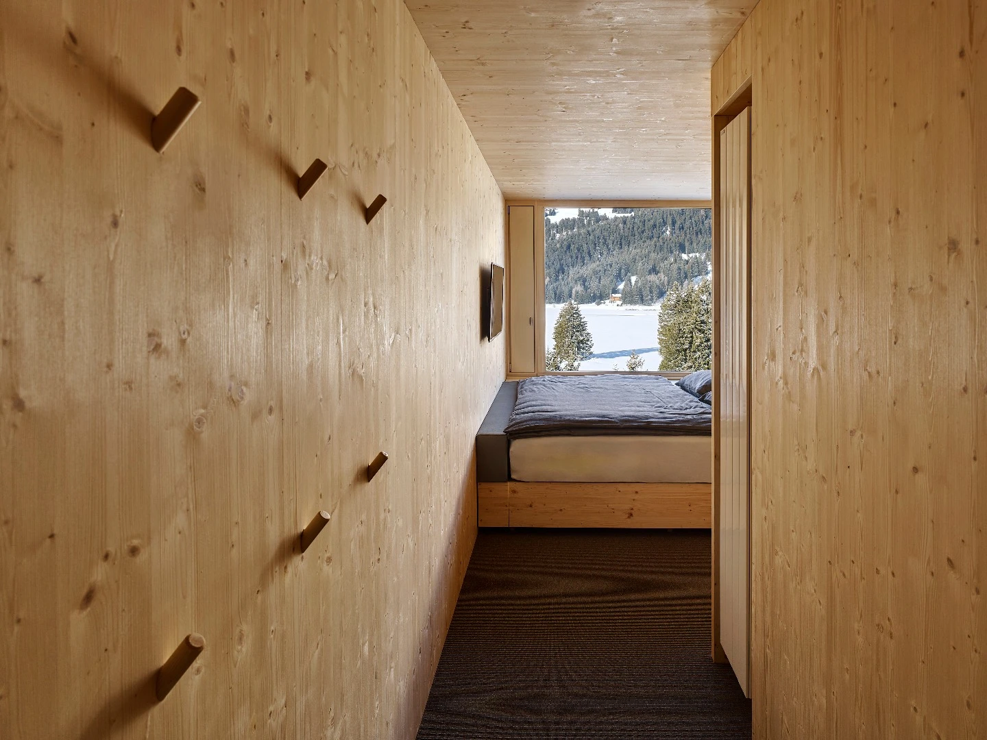 Each of the 96 rooms making up the four floors of the Revier Mountain Lodge was crafted from natural unfinished plywood and fabricated off site