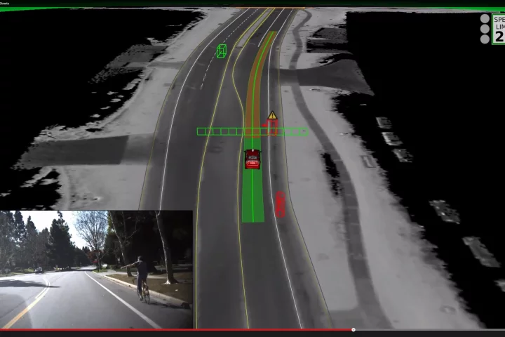 Google's self driving car waits for a cyclist who is making a hand signal