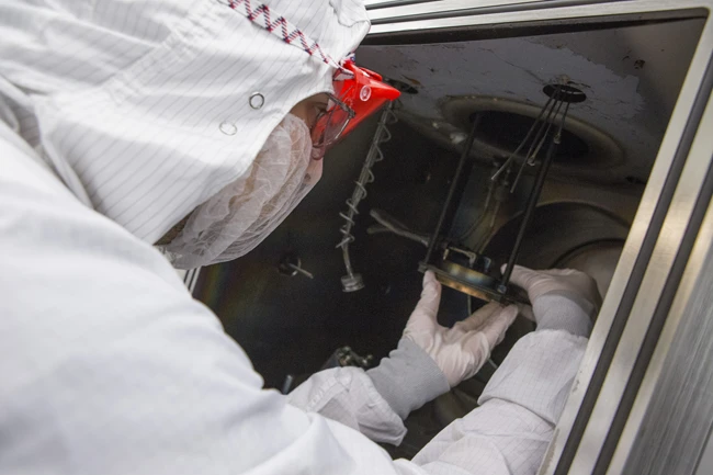 Kats places the paper inside the electron-beam evaporator (Photo: Eliza Grinnell)