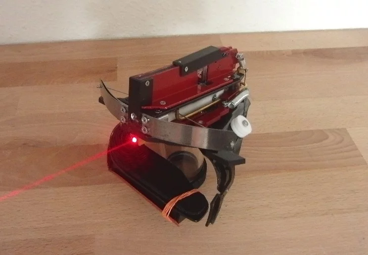 It uses a 2-milliwatt red laser to assist in aiming