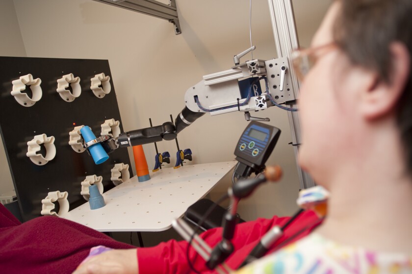 Jan Scheuermann stacks cones with a mind-controlled robot arm (Photo: UPMC)