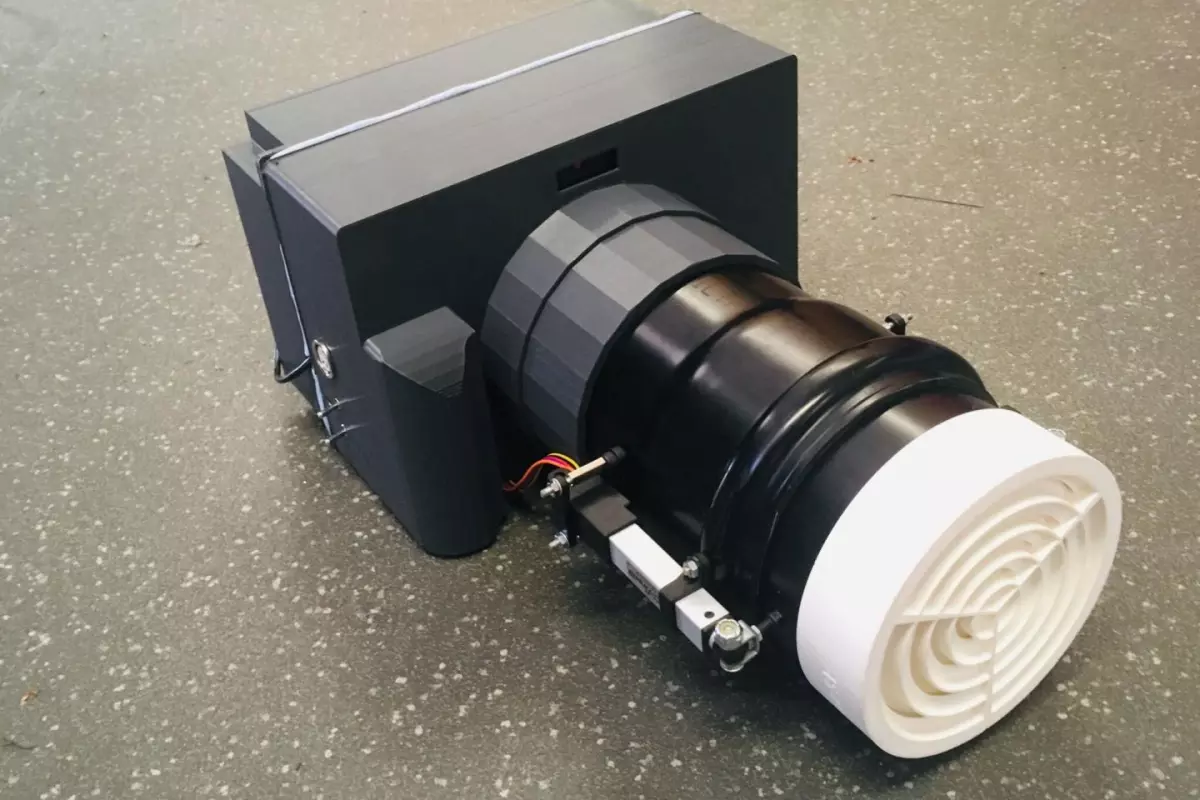 The prototype device incorporates one fixed acoustic lens in the back, along with another in the front (white) that moves in and out as the target comes closer or moves farther away