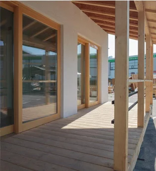 The southern side features large open windows and sliding doors that open out onto the shaded balcony terrace with overhead veranda