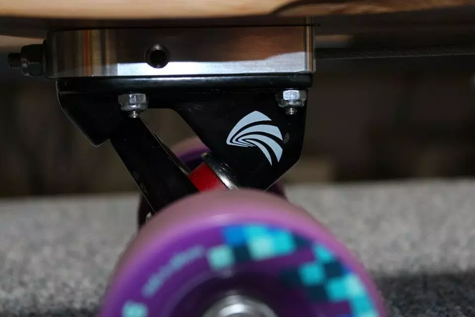 The billeted aluminum blocks sit between the trucks and deck