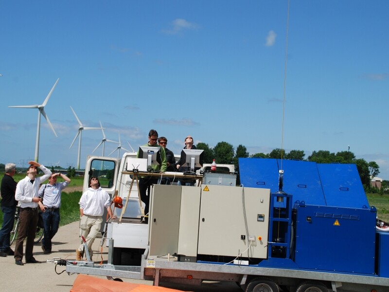 The compact winch base station with wind turbines in the background