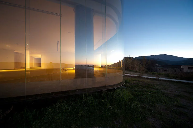 The main facade of the structure boasts impressive floor to ceiling glass panels, which reflect the surrounding landscape views